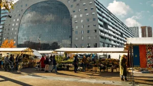 Sfeer impressie van de Markthal met de gezellige wekelijkse markt op de voorgrond.